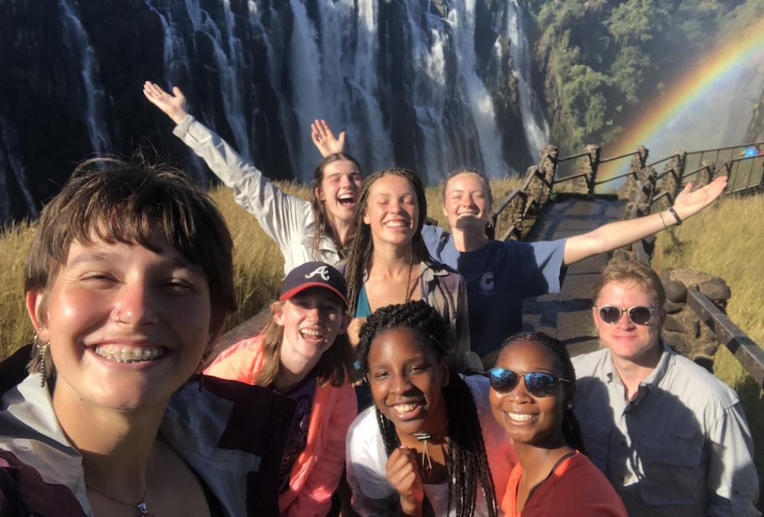 Students Taking Selfie in Front of Waterfall and Rainbow.