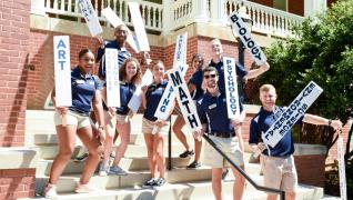 orientation team holds up signs for each program