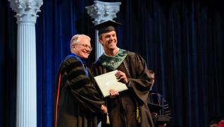 student receiving diploma from dean