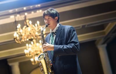 student playing saxophone in ballroom