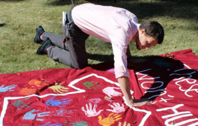 students placing handprint on banner