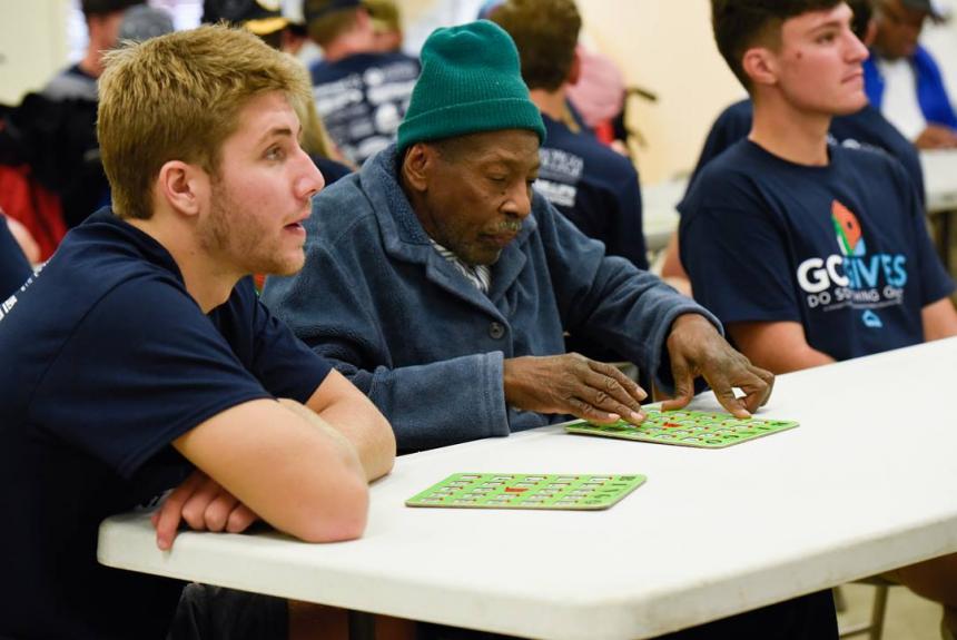 students helping man play bingo