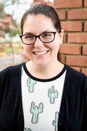 Photo of Melissa Gerrior, a white woman with brown hair. She is wearing glasses and a t-shirt with cactus print