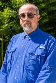 John Trombley in a long sleeve blue dress shirt.