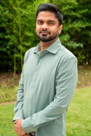 Nishant Karadkhelkar in a long sleeve green dress shirt.