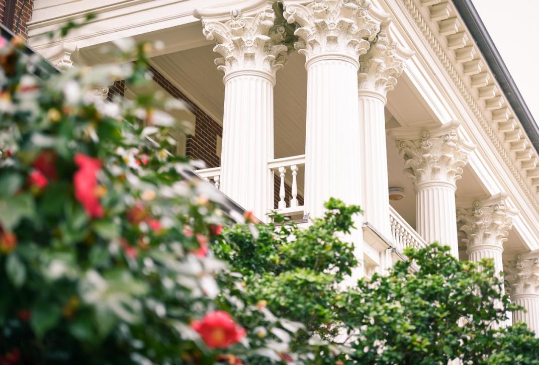 view of ornate columns on building and rose bushes