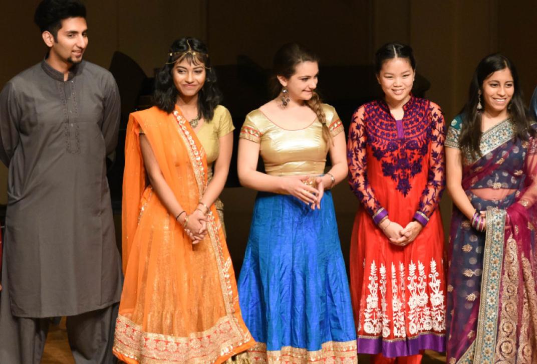 students in cultural attire on stage