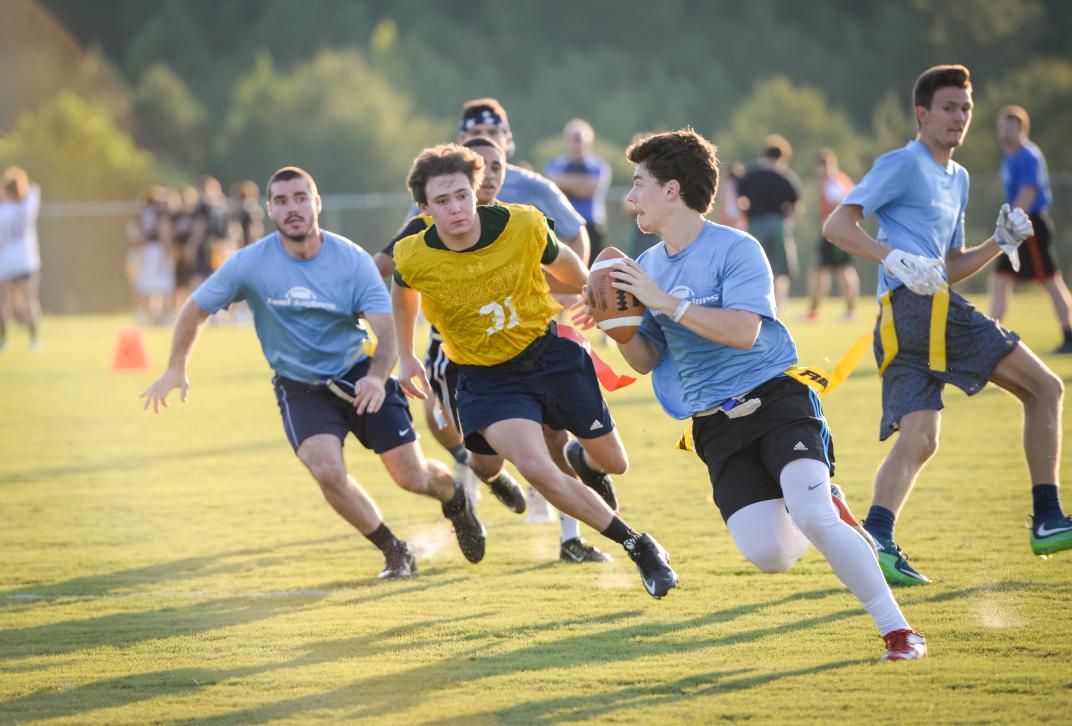 male students play flag football