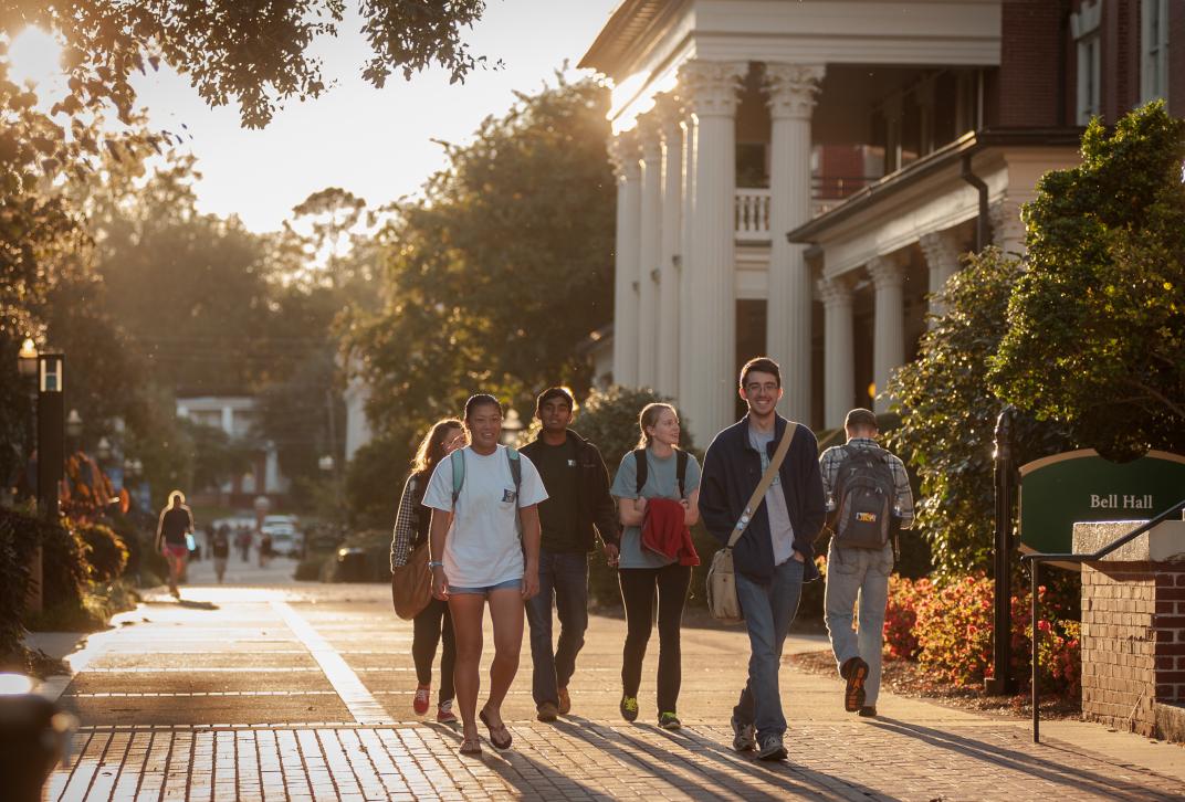 Students walking on Front Campus as the sun sets