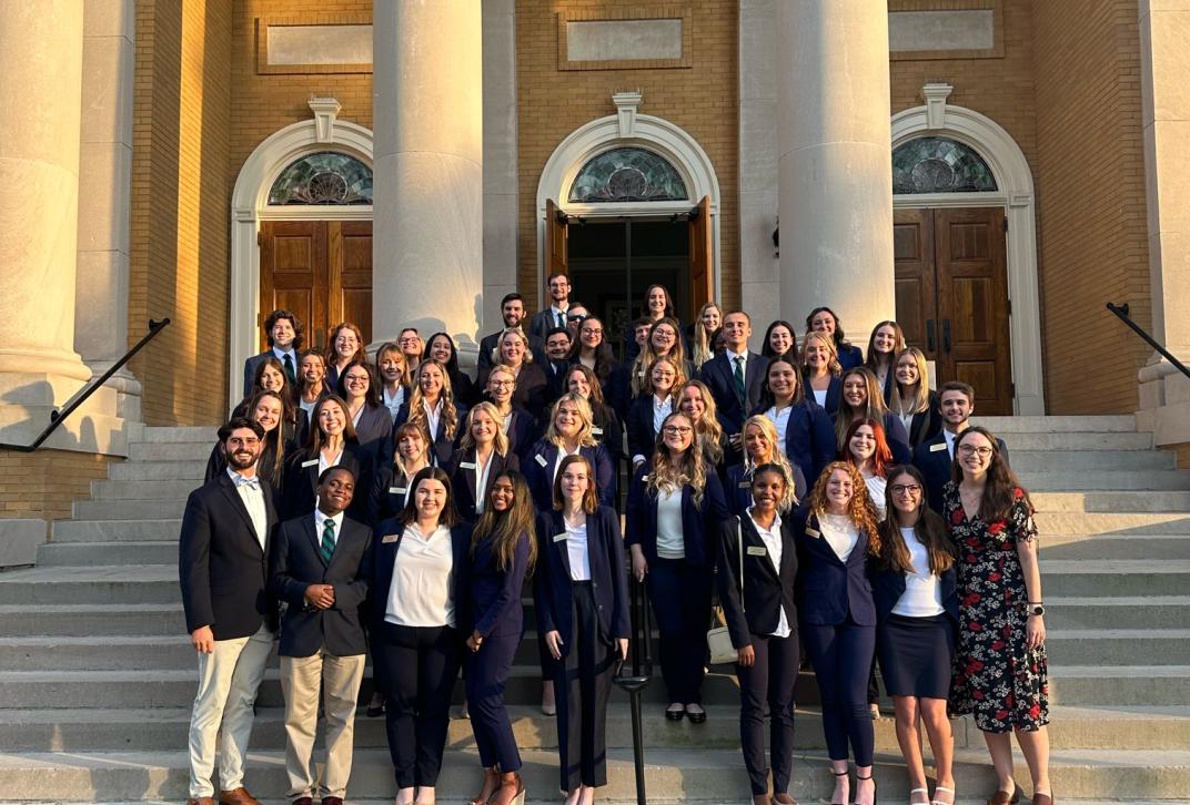 The Council of Student Ambassadors pose on the front steps of Magnolia Ballroom is matching blue suits.