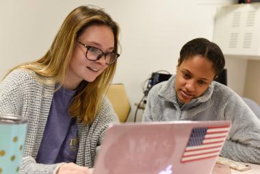 two female students look at a compute