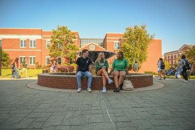 Students sitting on the fountain on Georgia College's campus.
