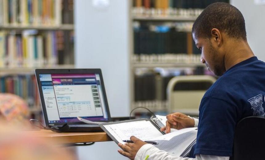 student in library at laptop