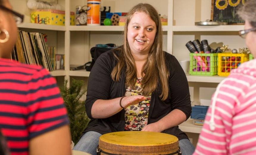 student using drum in group therapy