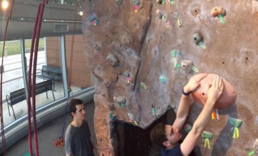 Student bouldering on climbing wall