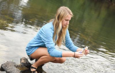 Student checks water quality in river