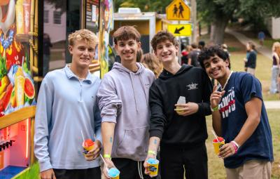 four students at the housing feline fun fair with snow cones