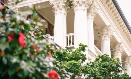 view of ornate columns on building and rose bushes