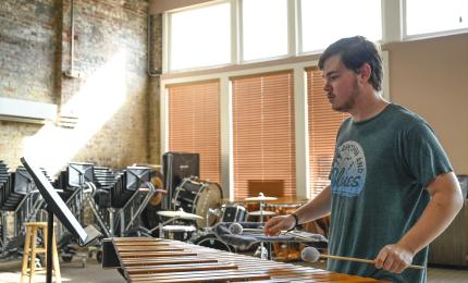 A student plays a xylophone