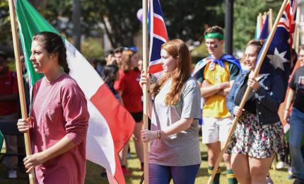 students hold flags at international day on gcsu's front campus