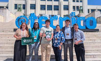 Five GCSU students and their professor on the steps outside the international research conference