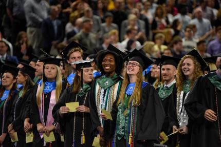 Graduates smile at each other during the May 2019 ceremony.