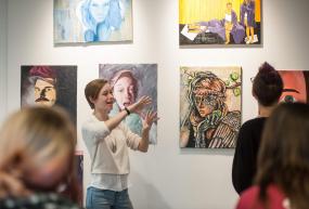 woman explaining art in gallery